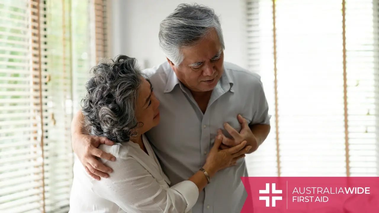 An elderly woman props up her husband while he has a heart attack